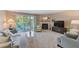 Cozy carpeted living room featuring fireplace, comfortable seating, and sliding glass door to patio at 615 Garland Cir, Indian Rocks Beach, FL 33785