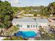 Aerial view of the property with a beautiful backyard pool, surrounded by mature landscaping and neighborhood at 6235 Viola Ln, New Port Richey, FL 34653