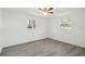 A bright bedroom with vinyl flooring, white walls, and two windows bringing in natural light at 6235 Viola Ln, New Port Richey, FL 34653
