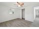 Cozy bedroom features a ceiling fan, natural light, closet and light gray flooring at 6235 Viola Ln, New Port Richey, FL 34653