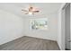 Bright bedroom features a ceiling fan, light gray flooring and bright sunlit window at 6235 Viola Ln, New Port Richey, FL 34653