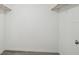 A walk-in closet with minimal shelving, white walls and light gray flooring at 6235 Viola Ln, New Port Richey, FL 34653