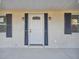 Close up of front door with black shutters and lamps at 6235 Viola Ln, New Port Richey, FL 34653