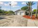 Large two-car garage with an expansive driveway and tropical landscaping at 6235 Viola Ln, New Port Richey, FL 34653