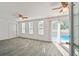 Bright living room with light gray floors has direct access to the outdoor pool at 6235 Viola Ln, New Port Richey, FL 34653