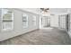 Bright living room with sleek, gray flooring, multiple windows, and ceiling fans at 6235 Viola Ln, New Port Richey, FL 34653