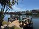 Tranquil waterfront dock view with boat lift and seating, perfect for enjoying the serene canal and neighborhood at 6319 Cocoa Ln, Apollo Beach, FL 33572