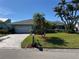Charming home with a well-manicured lawn, palm trees, and a brick driveway at 6319 Cocoa Ln, Apollo Beach, FL 33572