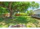 Backyard featuring a grassy area, shady trees, deck, fire pit, and foliage at 6426 31St S St, St Petersburg, FL 33712
