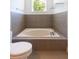Elegant bathroom with a built-in tub and neutral tiled walls at 6426 31St S St, St Petersburg, FL 33712