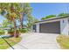 Single-story home featuring a spacious driveway, two-car garage, and palm tree at 6426 31St S St, St Petersburg, FL 33712