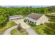 Aerial view showcasing the house, detached garage, long driveway, and manicured landscaping at 6448 Country Club Rd, Wesley Chapel, FL 33544