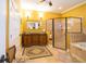 Spacious bathroom featuring dual vanities, walk-in shower, and a soaking tub at 6448 Country Club Rd, Wesley Chapel, FL 33544