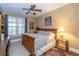 Inviting bedroom with natural light, neutral walls, wood floors, ceiling fan and classic furnishings at 6448 Country Club Rd, Wesley Chapel, FL 33544