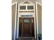 Elegant front door with decorative glass and white trim, showcasing the home's charming facade at 6448 Country Club Rd, Wesley Chapel, FL 33544