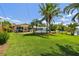 Expansive backyard with lush lawn, mature palms, and a beautiful pool and patio area at 6667 28Th S St, St Petersburg, FL 33712