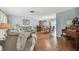 Open-concept living room with hardwood floors, comfortable sofa, and a view into the formal dining room at 6667 28Th S St, St Petersburg, FL 33712