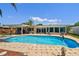 Sparkling swimming pool surrounded by a brick patio, lounge furniture, and a covered patio area at 6667 28Th S St, St Petersburg, FL 33712