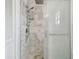 Elegant marble tiled shower featuring multiple shower heads and frameless glass doors at 6667 28Th S St, St Petersburg, FL 33712
