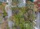 Aerial view showing the layout of the property and its surroundings, including nearby streets and foliage at 7819 Chasco St, Port Richey, FL 34668