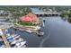 Aerial view showcases a waterfront restaurant with boat docks, a scenic bridge, and lush landscaping at 7819 Chasco St, Port Richey, FL 34668