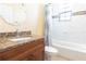 Bathroom with granite-topped vanity, shower-tub combination, and mosaic tile accents at 810 W Whatley Pl, Tampa, FL 33604