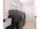 Laundry room has a modern washer and dryer, plus a window and door at 810 W Whatley Pl, Tampa, FL 33604