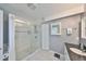 Tiled bathroom featuring a walk-in shower, white cabinets, and a gray accent wall at 8420 Orient Ne Way, St Petersburg, FL 33702
