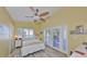 Cozy bedroom with wood-look floors, ceiling fan, and double doors leading to outdoor area at 8420 Orient Ne Way, St Petersburg, FL 33702