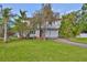 Charming two-story home featuring a lush front yard with mature trees and a cozy entrance at 8420 Orient Ne Way, St Petersburg, FL 33702