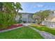 Well-maintained front yard with lush green grass and an inviting walkway to the entrance at 8420 Orient Ne Way, St Petersburg, FL 33702