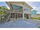 Two-story home featuring a screened-in porch, open upper deck and an outdoor staircase at 8420 Orient Ne Way, St Petersburg, FL 33702