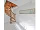 Unique spiral wooden staircase with white-tiled floor and natural lighting at 8420 Orient Ne Way, St Petersburg, FL 33702