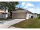 A two-car garage with mature landscaping and a long driveway at 10108 36Th E Ct, Parrish, FL 34219