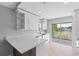 Well-lit kitchen boasts white cabinets, quartz countertops, and a sliding glass door to backyard at 10108 36Th E Ct, Parrish, FL 34219