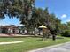 A community playground with swings and slides, surrounded by lush greenery and landscaping at 10108 36Th E Ct, Parrish, FL 34219