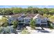 Aerial view of blue townhouses with dark garage doors, complemented by lush greenery and paved driveways at 1110 Rose Blossom Ct, Tampa, FL 33613