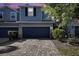 Beautiful townhome with a two-car garage, paver driveway, and well-manicured landscaping at 1110 Rose Blossom Ct, Tampa, FL 33613