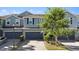 Charming townhome featuring a two-car garage, stone accents, and attractive landscaping at 1110 Rose Blossom Ct, Tampa, FL 33613