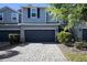 Beautiful townhouse showcasing a gray stone driveway and a two-car garage with manicured landscaping at 1110 Rose Blossom Ct, Tampa, FL 33613