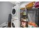 Functional laundry room features a stacked washer and dryer, plus shelving for storage at 1110 Rose Blossom Ct, Tampa, FL 33613