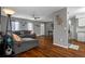 Open living room with hardwood floors, a gray sectional sofa, and a view into the kitchen area at 12280 Waco St, Spring Hill, FL 34609