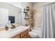 Bathroom with a single sink vanity, tile flooring, shower with shower curtain and wall shelving at 12519 Safari Ln, Riverview, FL 33579
