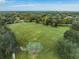 Aerial view of a large grassy field with trees, benches, and a backstop in a well-maintained community at 12519 Safari Ln, Riverview, FL 33579