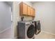 Modern laundry room equipped with front-load washer and dryer and lots of cabinet space at 12519 Safari Ln, Riverview, FL 33579