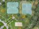 Aerial view of tennis courts, a basketball court and sand volleyball area in a park-like setting within the community at 12519 Safari Ln, Riverview, FL 33579