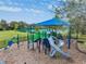 Community playground with multiple slides, climbing features, and shaded picnic area at 12519 Safari Ln, Riverview, FL 33579