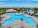 Aerial view of a community pool, splash pad, and cabana near a lake and residential homes at 12519 Safari Ln, Riverview, FL 33579
