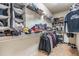 Spacious walk-in closet filled with hanging clothes, folded items, and shoe racks for organization at 12519 Safari Ln, Riverview, FL 33579