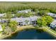 Aerial view highlighting screened-in patios of lakeside condo buildings surrounded by trees at 1309 Pine Ridge E Cir # H3, Tarpon Springs, FL 34688